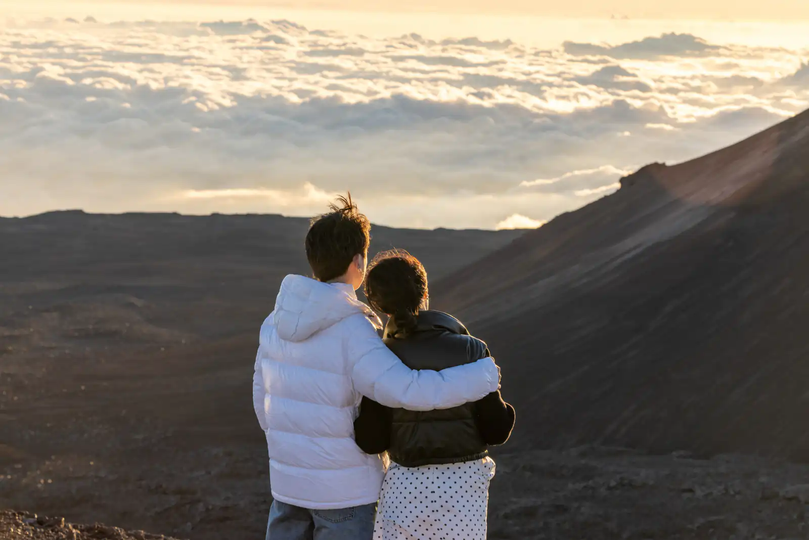 Couple posing for a picture on top of a hill